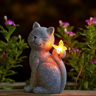 Cat sculpture with glowing butterfly in garden