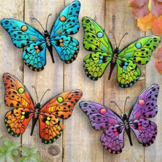 Colorful metal butterfly wall decorations in blue, green, orange, and purple on wooden background.