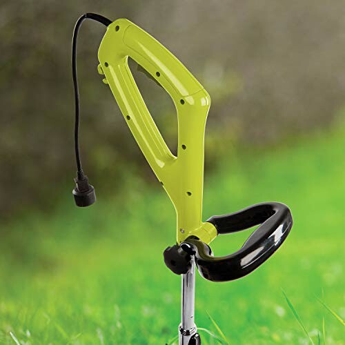 Electric weed trimmer handle on green lawn