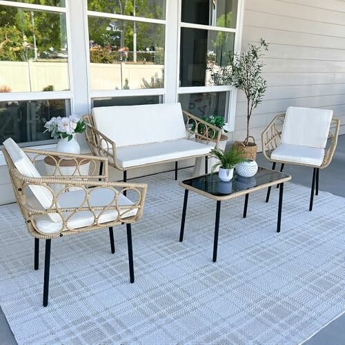 Outdoor patio with modern wicker furniture and white cushions.