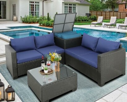 Outdoor patio furniture set with blue cushions beside a pool.