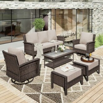 Outdoor patio furniture set with wicker chairs, sofa, and table on wooden deck.