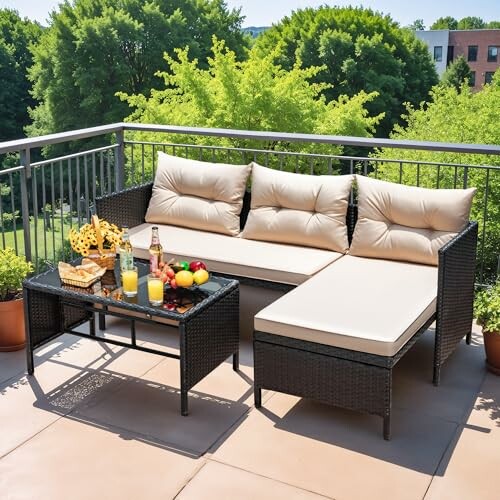 Outdoor patio furniture set with cushions, table with snacks and drinks, on a sunny balcony.