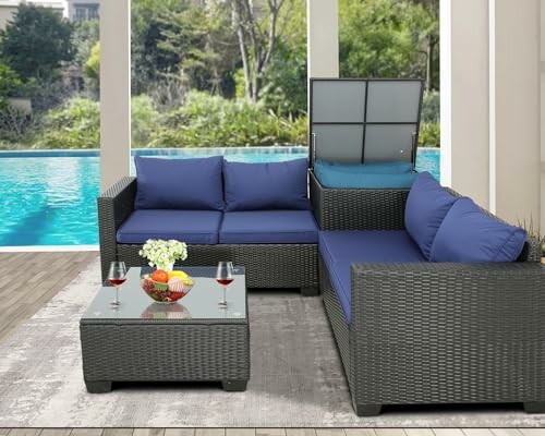 Outdoor patio furniture set with blue cushions by a pool.